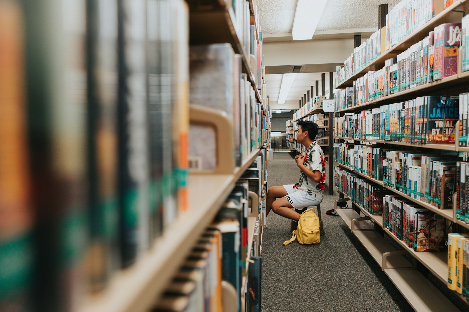 A student browsing a school library aisle
