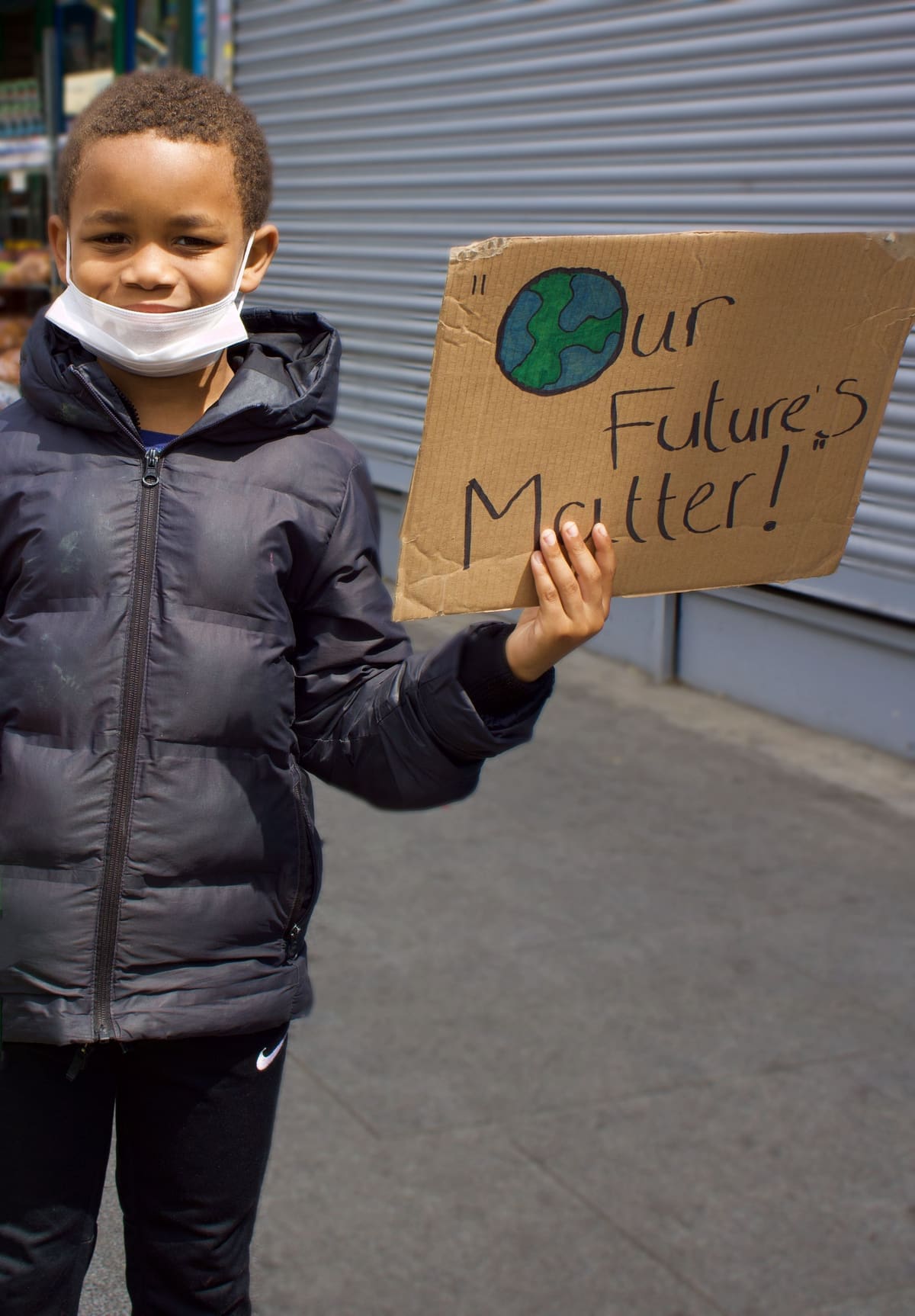 A child at a community march holding a hand-lettered "Our Future Matters" sign